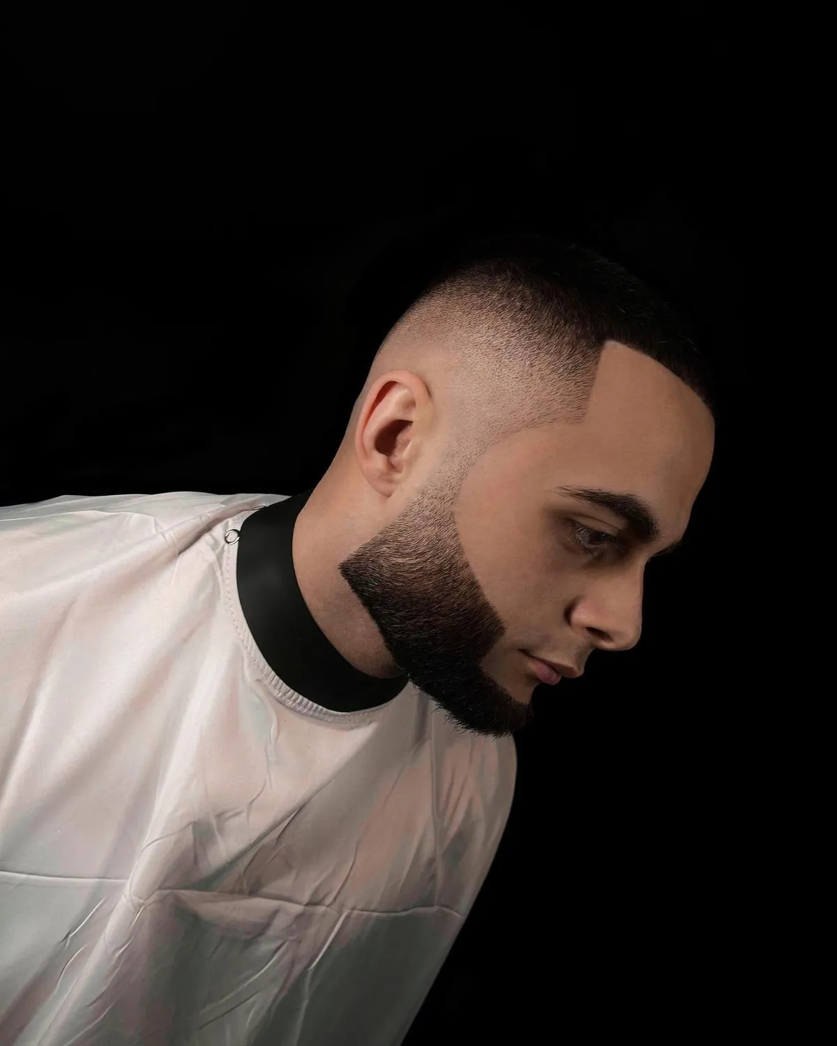 Buzz cut ar pāreju un īsa bārda ar asu kontūru, profils