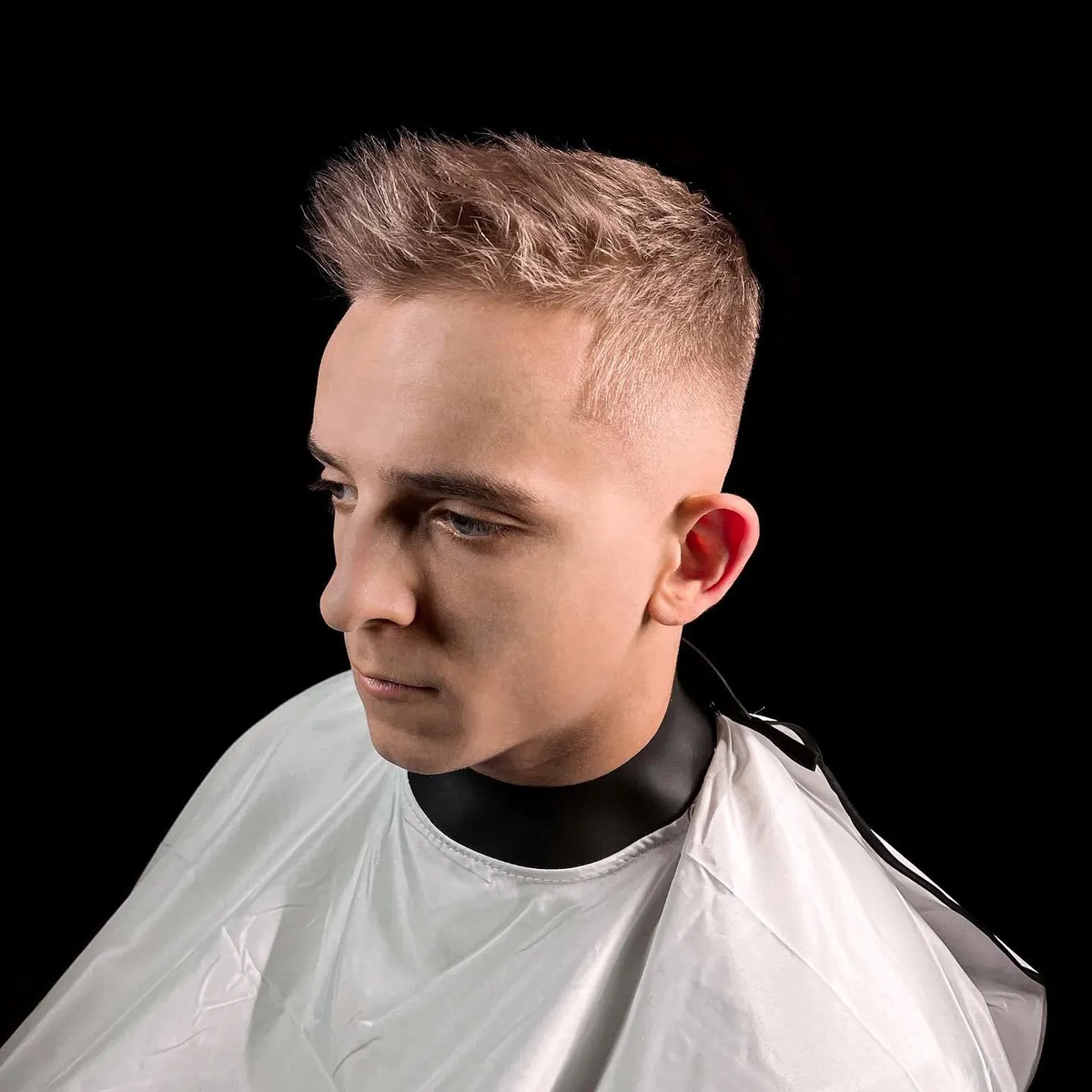 Gaišmatains vīrietis ar crew cut griezumu un mid fade pāreju